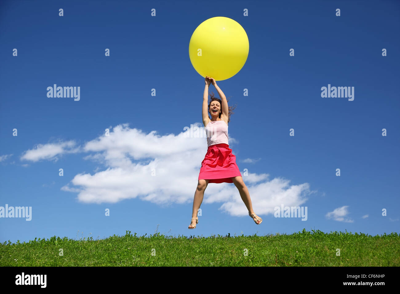 Frau canicular tagsüber steigen auf aufblasbaren Ball auf Rasen Stockfoto