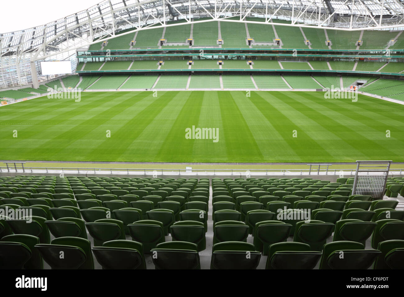 Grüne Sitzreihen in einem leeren Stadion. Vordersitze im Fokus Stockfoto