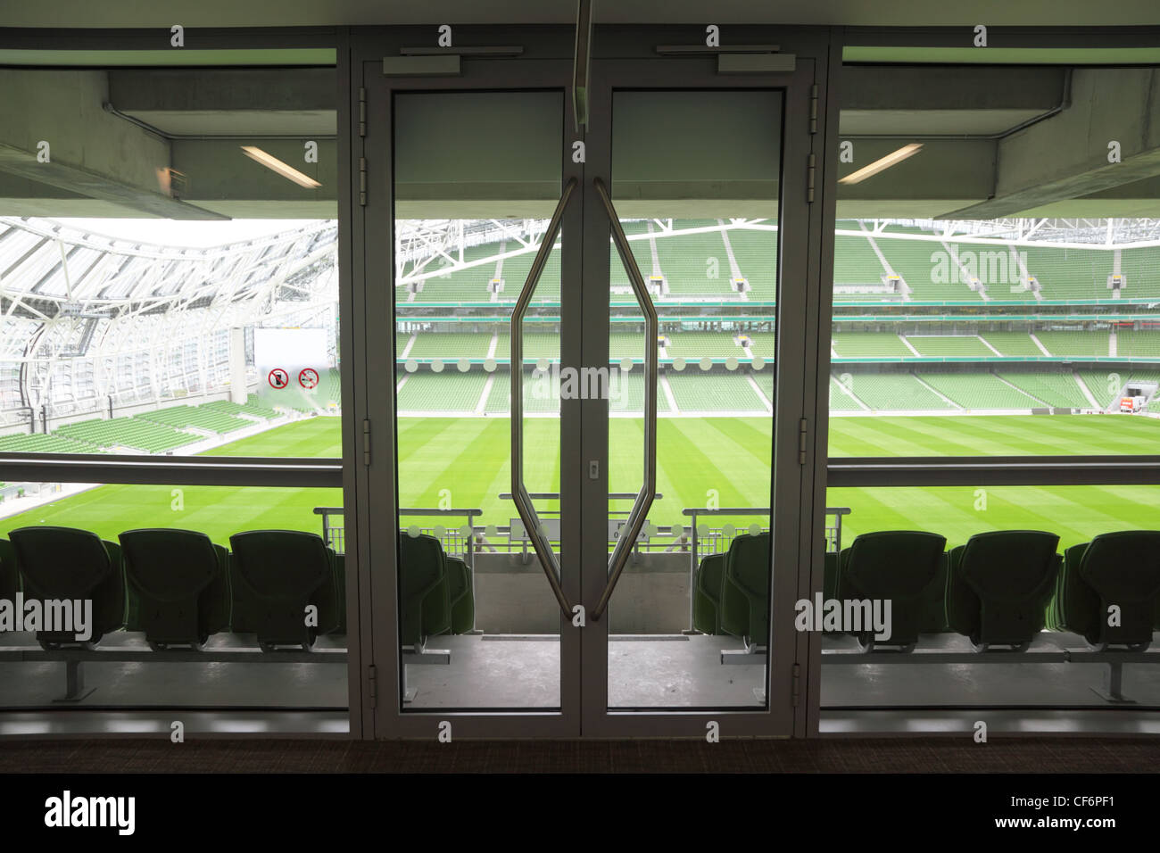 Tür und Reihen von Grün, in einem großen leeren Stadion Klappsitze. Stockfoto