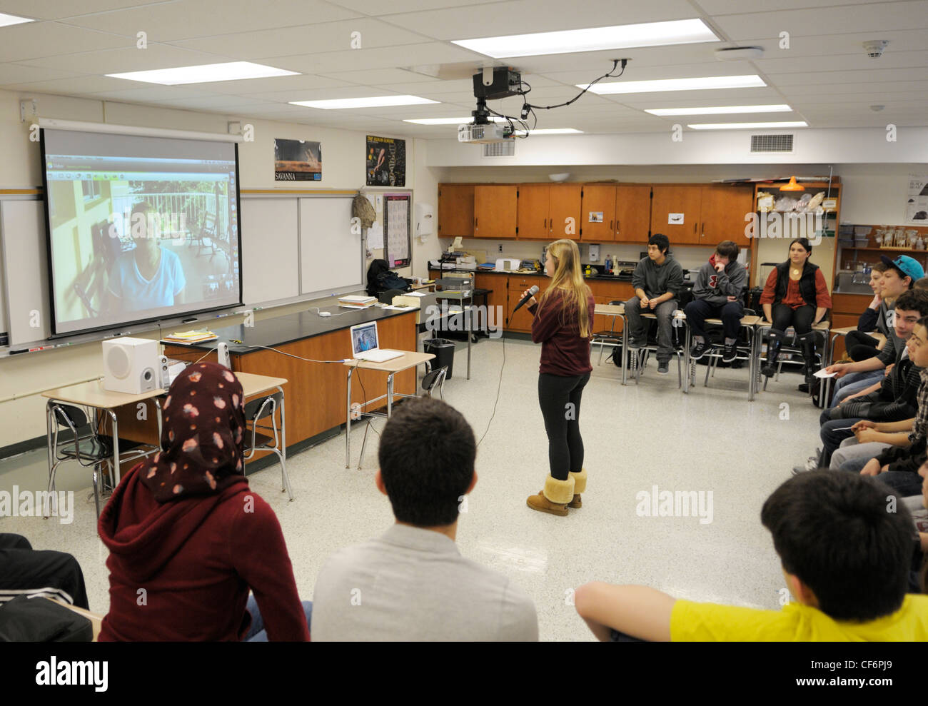 Klassenzimmer von amerikanischen Studenten Videokonferenzen mit einem Forscher auf eine Feldstation in Panama-Mädchen mit mic Frage Stockfoto
