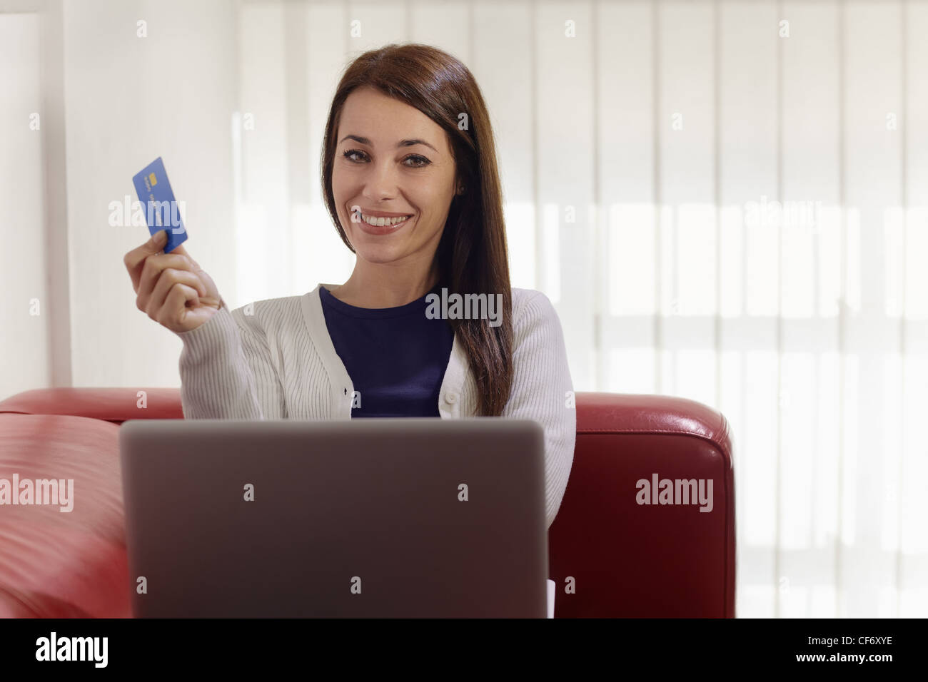 E-Commerce und fröhliche Frau, die mit pc und Kreditkarte beim Einkauf im Internet zu Hause Stockfoto