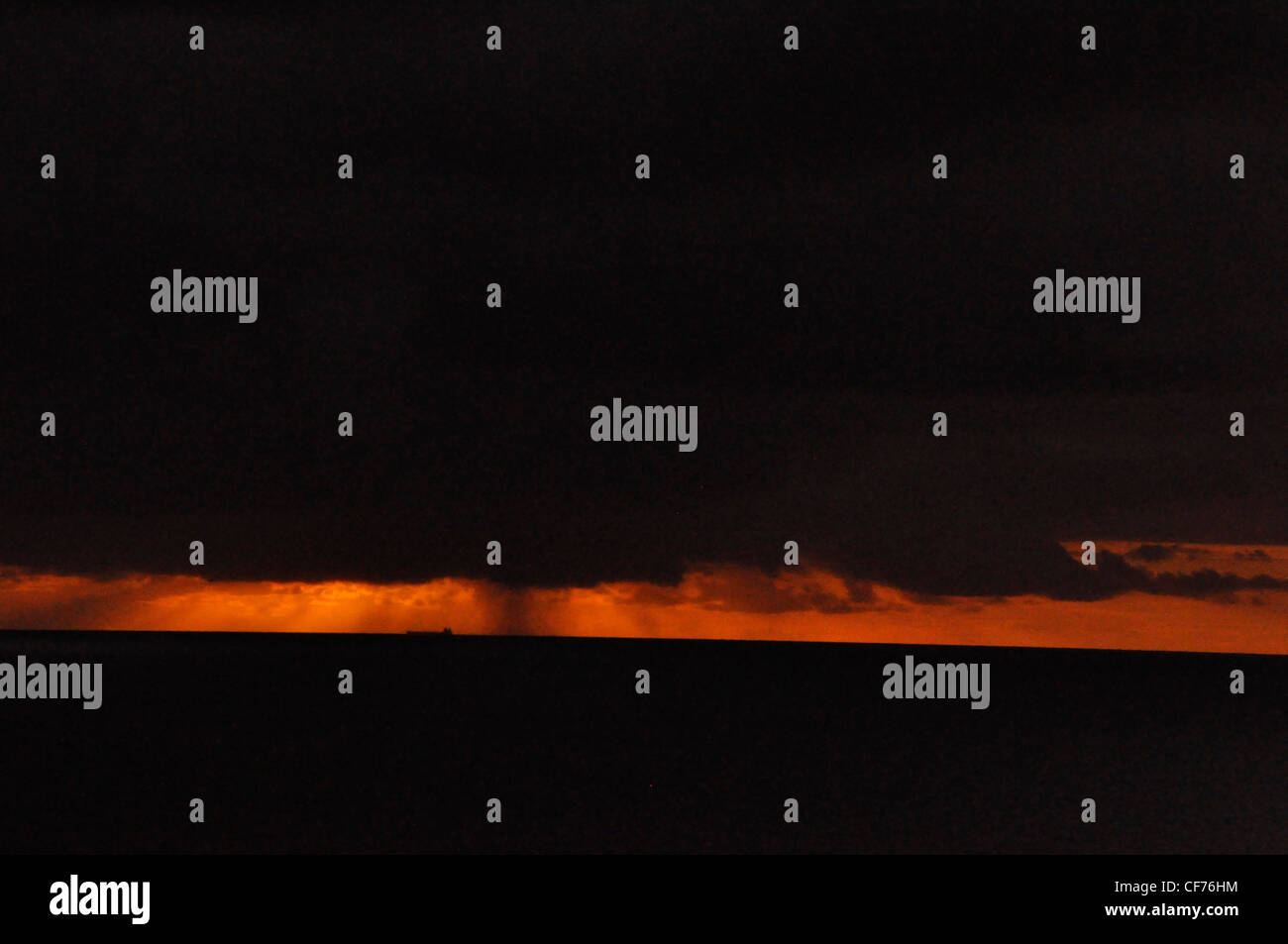 Black Sky & Sea Blazing Orange Wolken dramatische moody Stockfoto