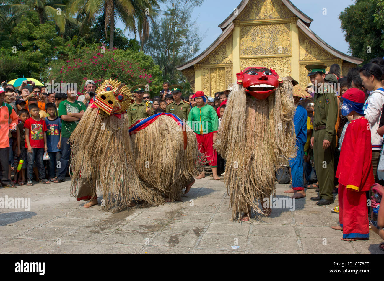 Maskierte Fabelwesen Singkaeo-Singkham und Nyar Nyer tanzen vor der goldenen Sim an Wat Xieng Thong auf Mue Nau, des mittlere Tages der Lao Neujahr (Pi Mai Lao), Luang Prabang, Laos Stockfoto