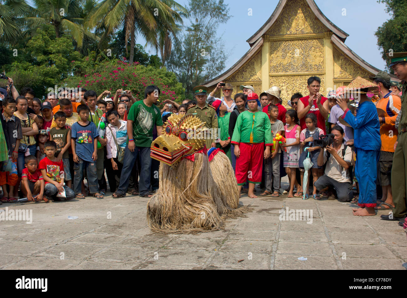 Mythische maskierte Löwe Figur Singkaeo-Singkham tanzen vor der goldenen Sim an Wat Xieng Thong auf Mue Nau, des mittlere Tages der Lao Neujahr (Pi Mai Lao), Luang Prabang, Laos Stockfoto