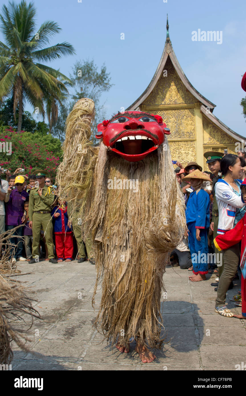 Maskierte Pou Nyer ein tanzen vor goldenen Sim am Wat Xieng Thong, Mue Nau, Lao Neujahr (Pi Mai Lao), Luang Prabang, Laos Stockfoto