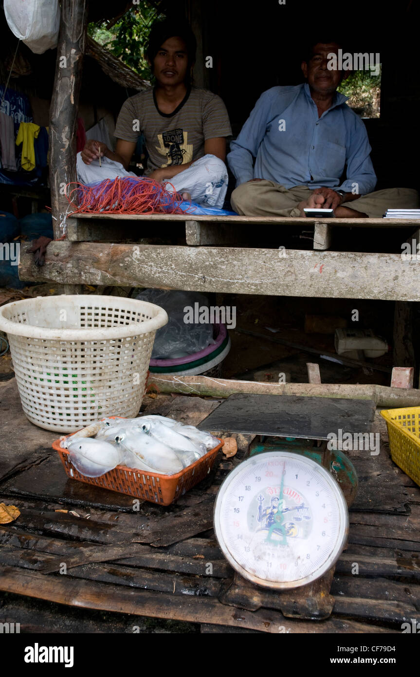 Fischer sitzen in Fischerhütte Verkauf von frisch gefangenen Fisch, Koh Bulon, Thailand Stockfoto