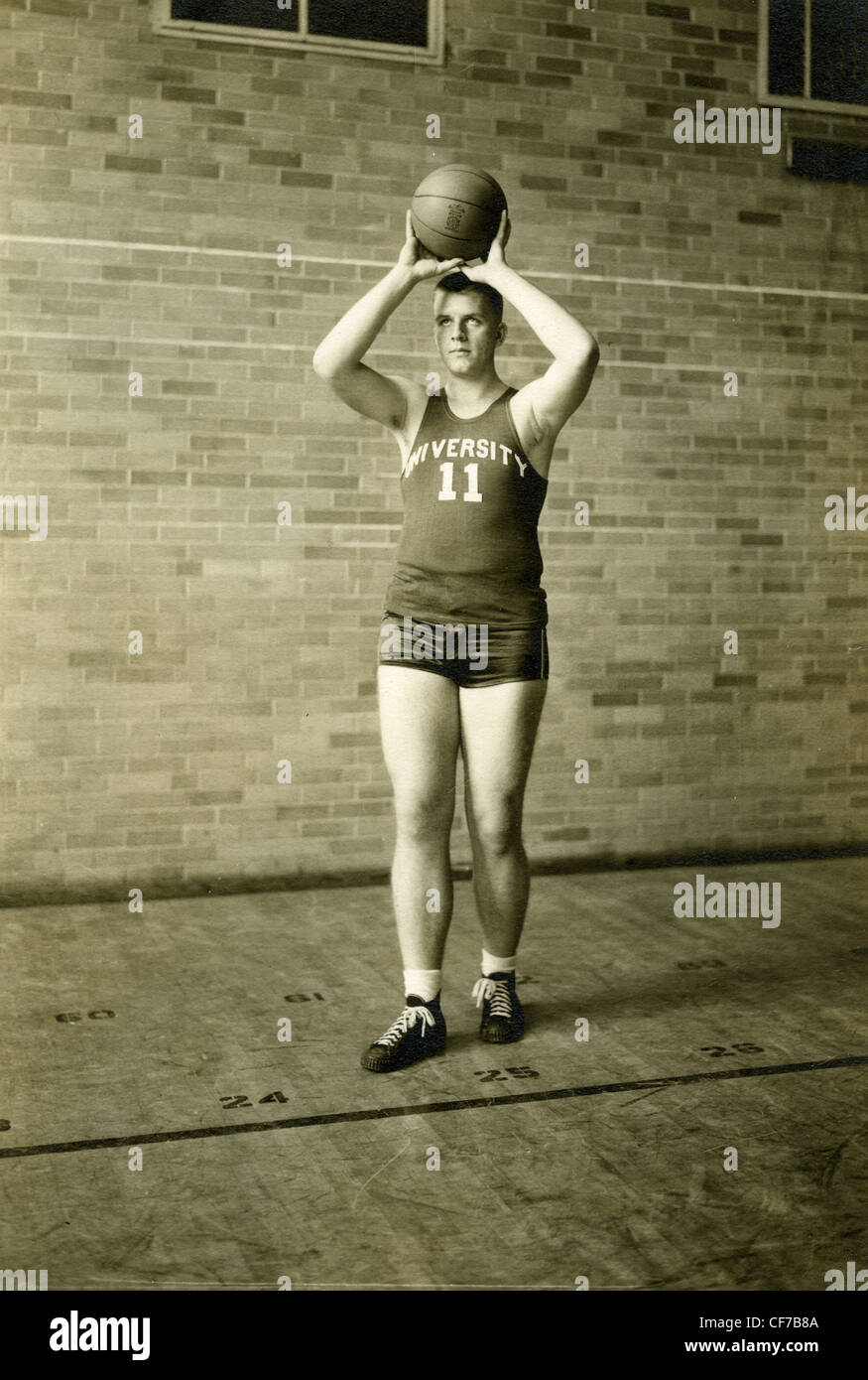 Universität-Basketball-Spieler Basketball während Porträt in 1945 oder 1946 Sport-Spieler der 1940er Jahre zu halten Stockfoto