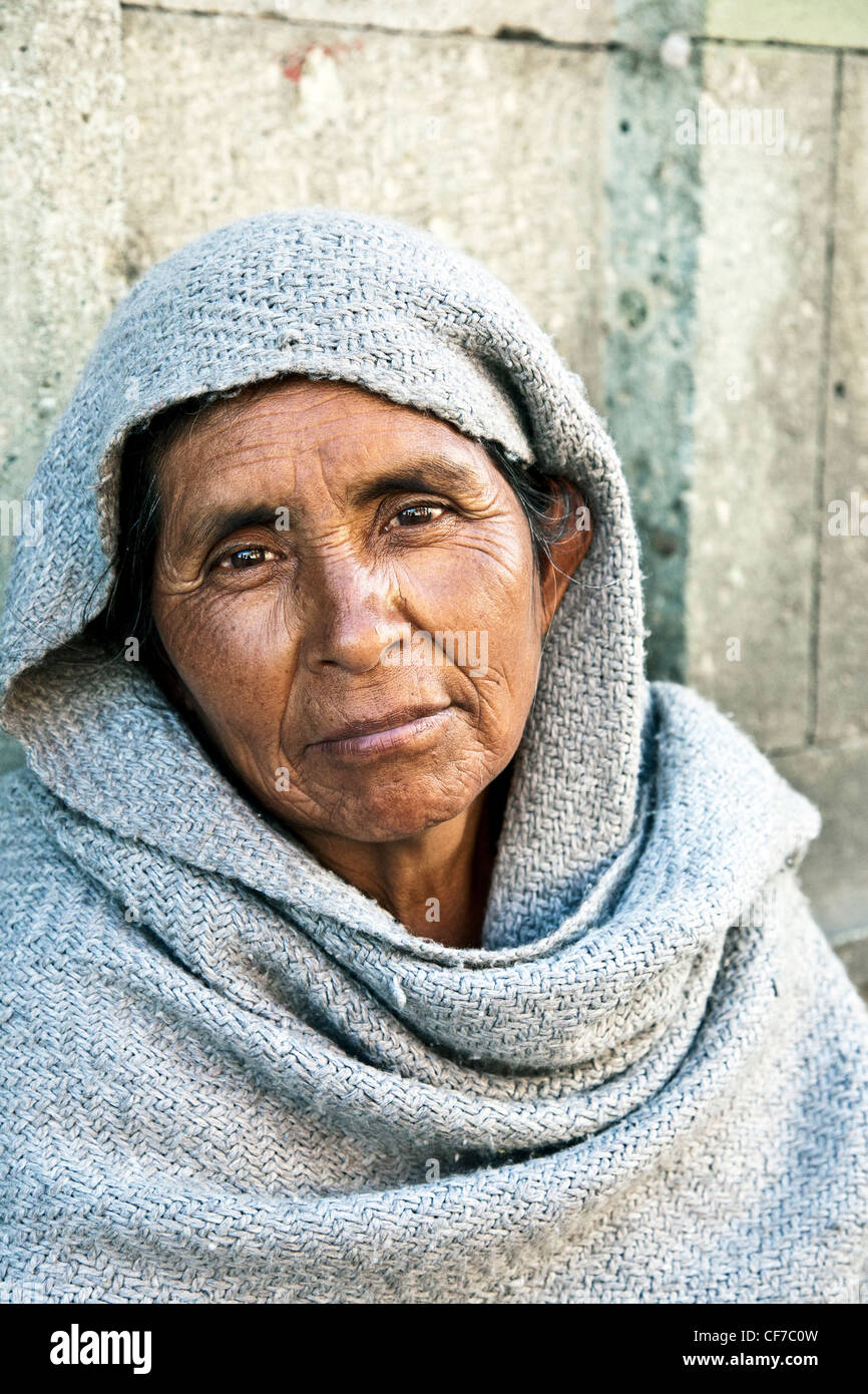 Straße Porträt schönen einheimischen Bettler Frau mit ausdrucksvollen dunklen Augen hockte gegen Steinmauer im Centro Bezirk Oaxaca Stockfoto