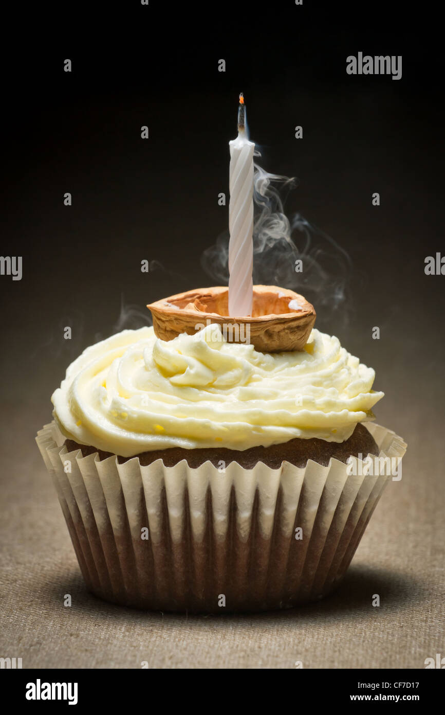 Ausblasen der Kerze auf Schoko-Muffin mit Vanillecreme Stockfoto