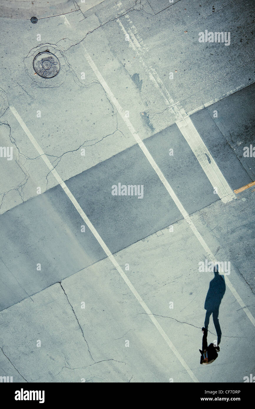 Schatten der einsame Mann die Straße überqueren. Stockfoto