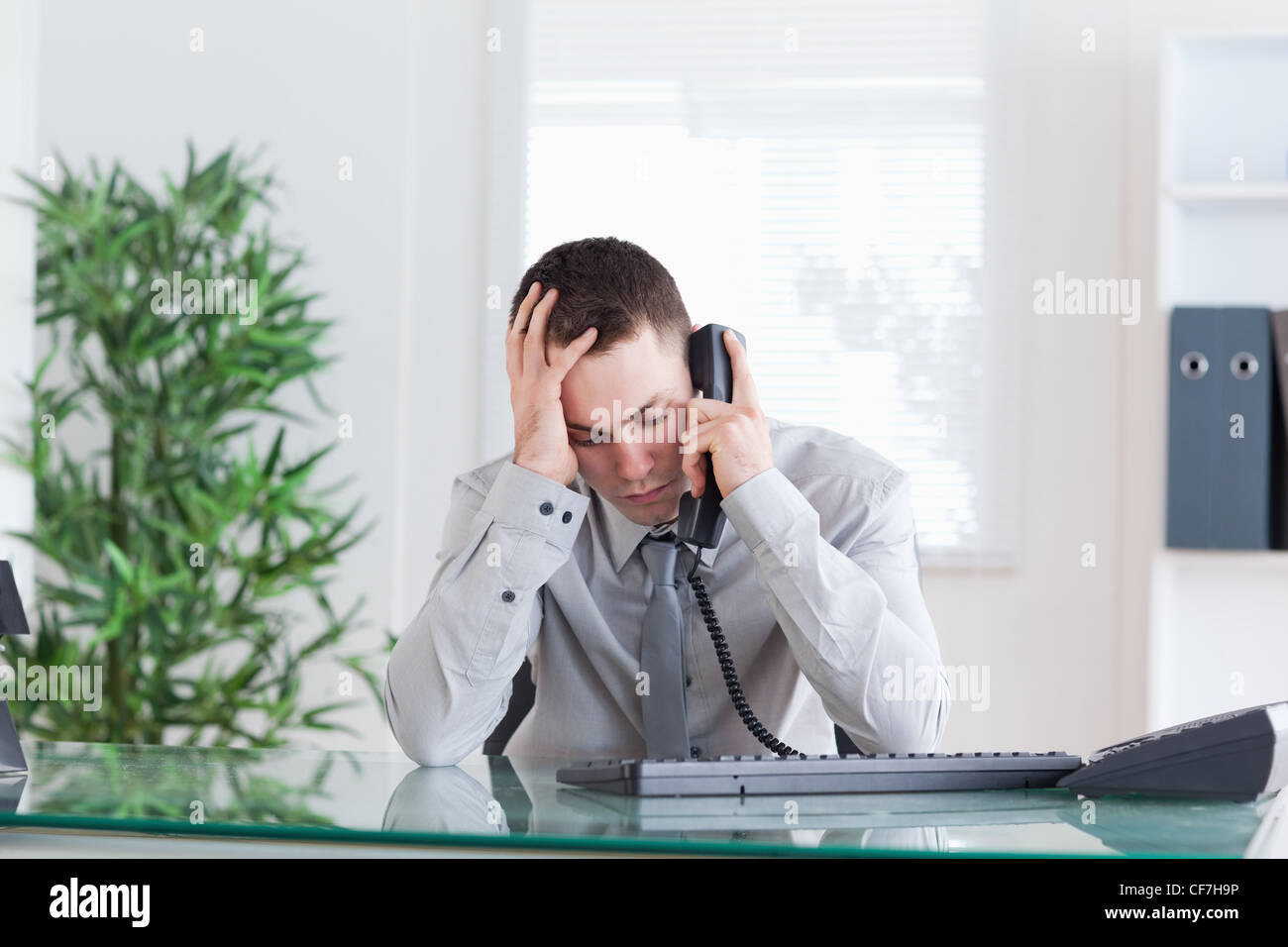 Geschäftsmann, traurige Nachrichten auf dem Handy Stockfoto