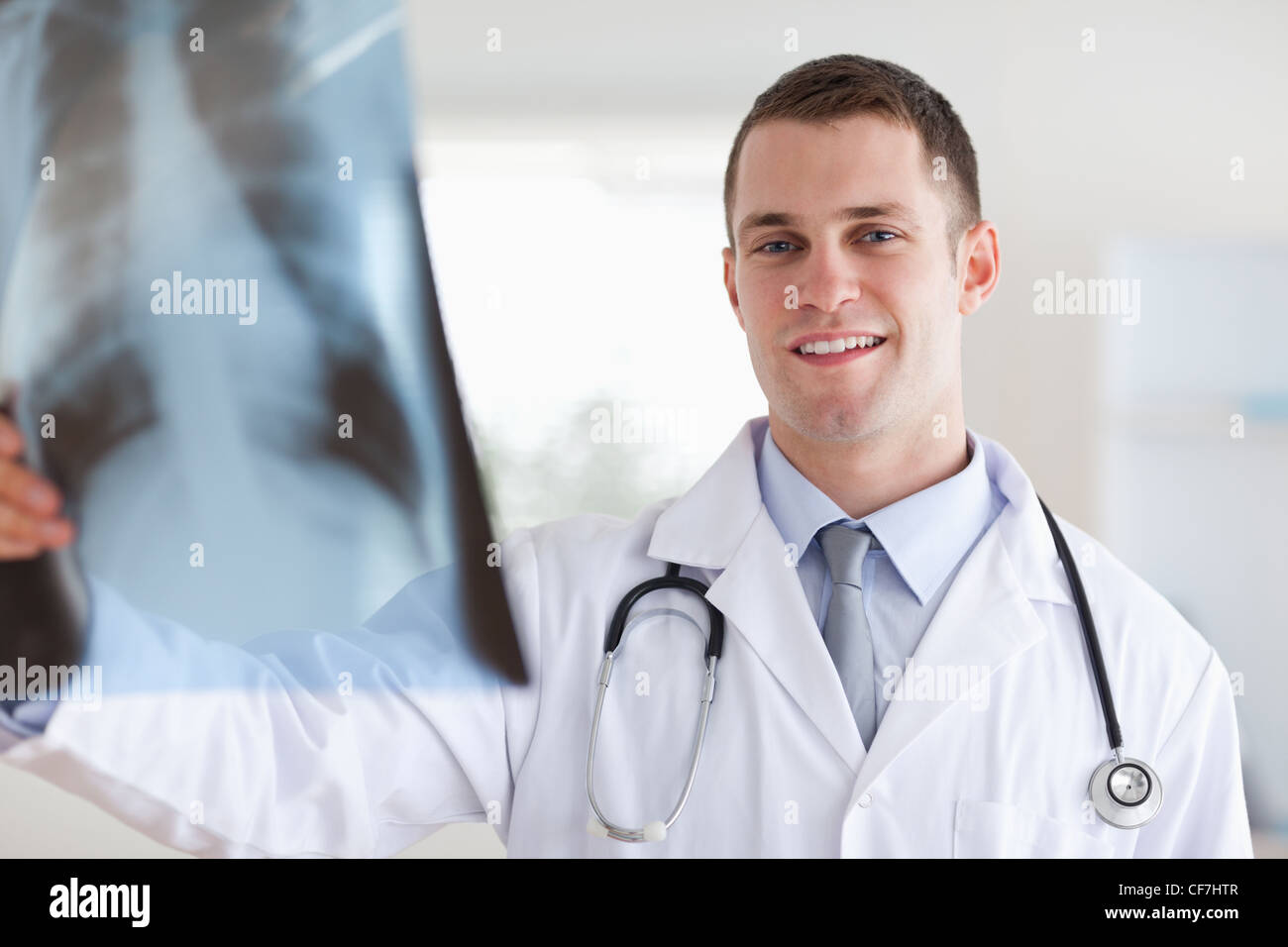 Lächelnde junge Ärztin Blick auf x-ray Stockfoto