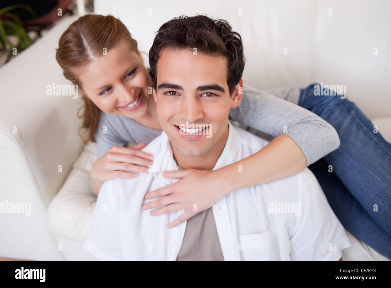 Mann immer von seiner Freundin auf dem Sofa umarmt Stockfoto