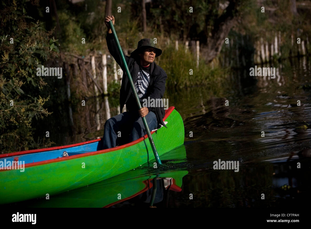 Ein Mann verwenden eine Kanu durch die Wasserkanäle von Xochimilco auf der Südseite von Mexiko-Stadt Stockfoto