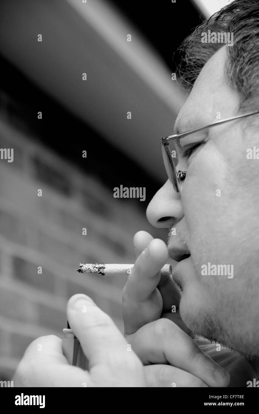 Mann Anzünden einer Zigarette-Model-release Stockfoto