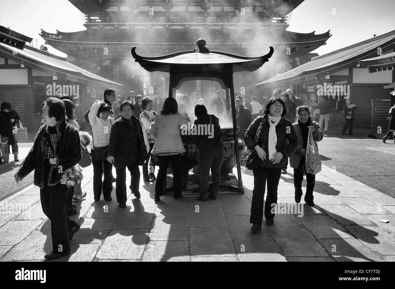 Touristen und Liebhaber um eine Weihrauch-Brenner am Sensoji Tempel in Tokio, Japan - schwarz / weiß Stockfoto