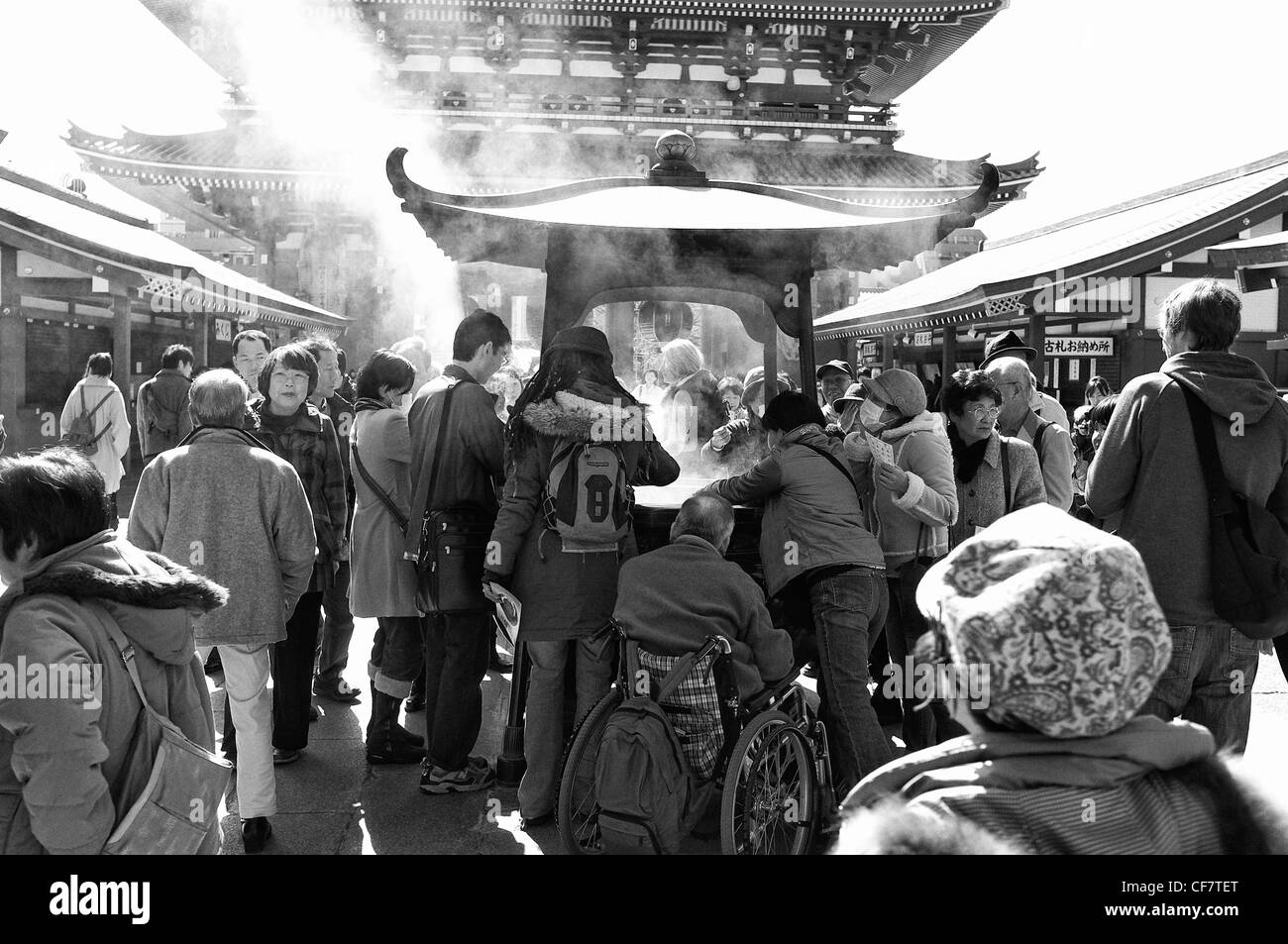 Touristen und Liebhaber um eine Weihrauch-Brenner am Sensoji Tempel in Tokio, Japan - schwarz / weiß Stockfoto