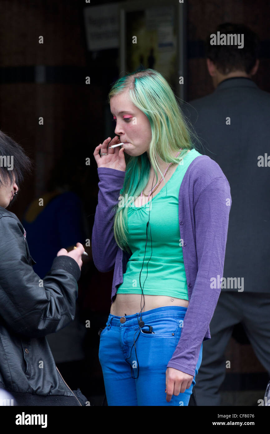 Mädchen mit grün gefärbten Haaren Rauchen außerhalb der Flinders Street Station, Melbourne, Australien Stockfoto