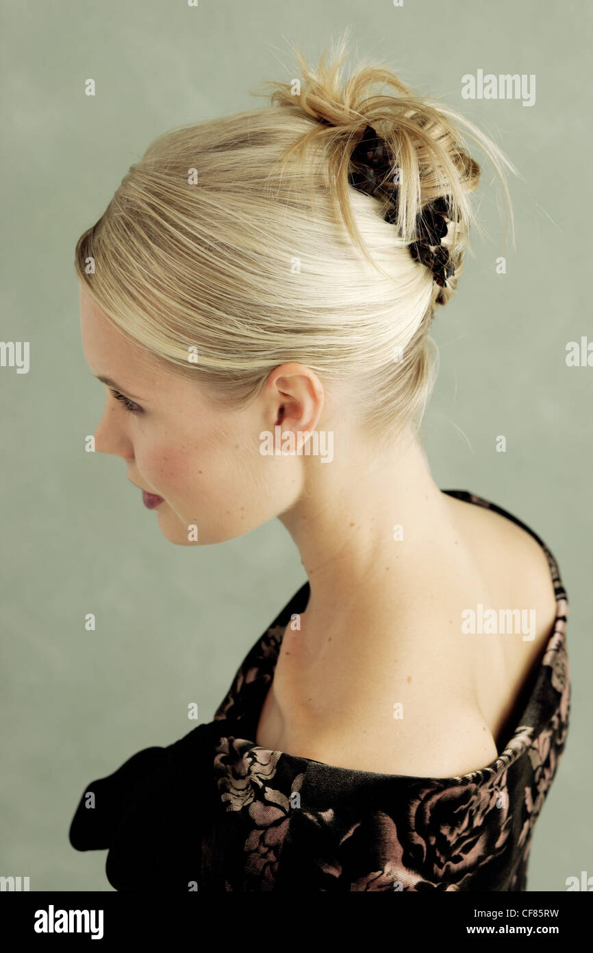 FORSide Blick auf blonde Frau trägt einen niedrigen u-Ausschnitt floral Top mit Haaren in einem Chignon merken mit floralen Haarnadeln Stockfoto