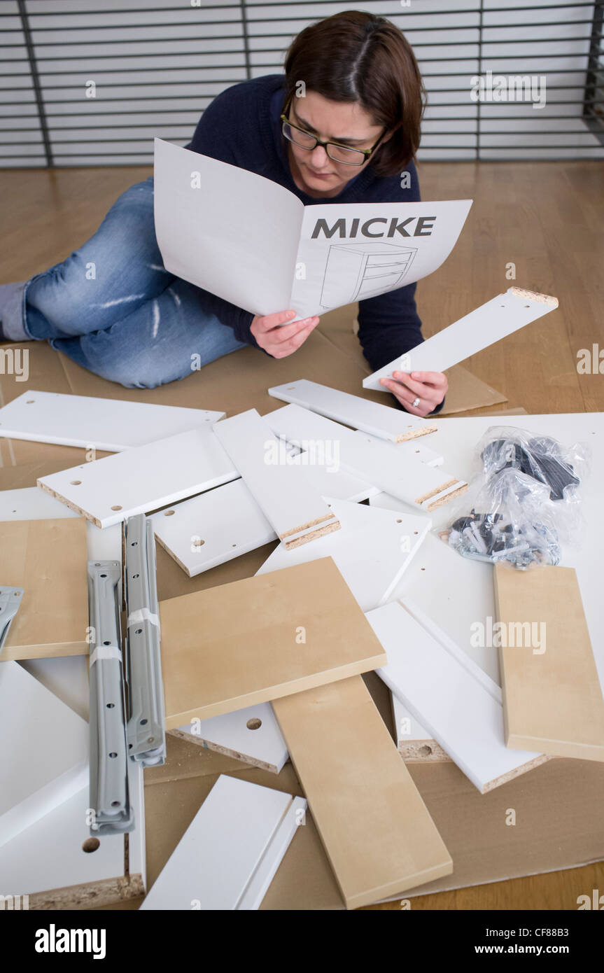 Frau, die Montage von Mitnahmemöbeln von IKEA zu Hause Stockfoto