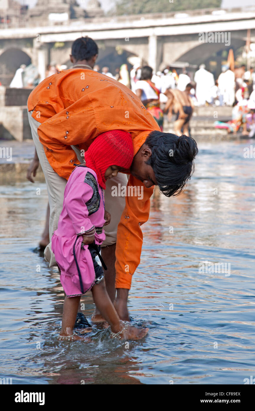 Vater der Fußwaschung seines Sohnes (hindu-Ritual). RAM "Kund". Godavari Fluß. Nasik. Indien Stockfoto