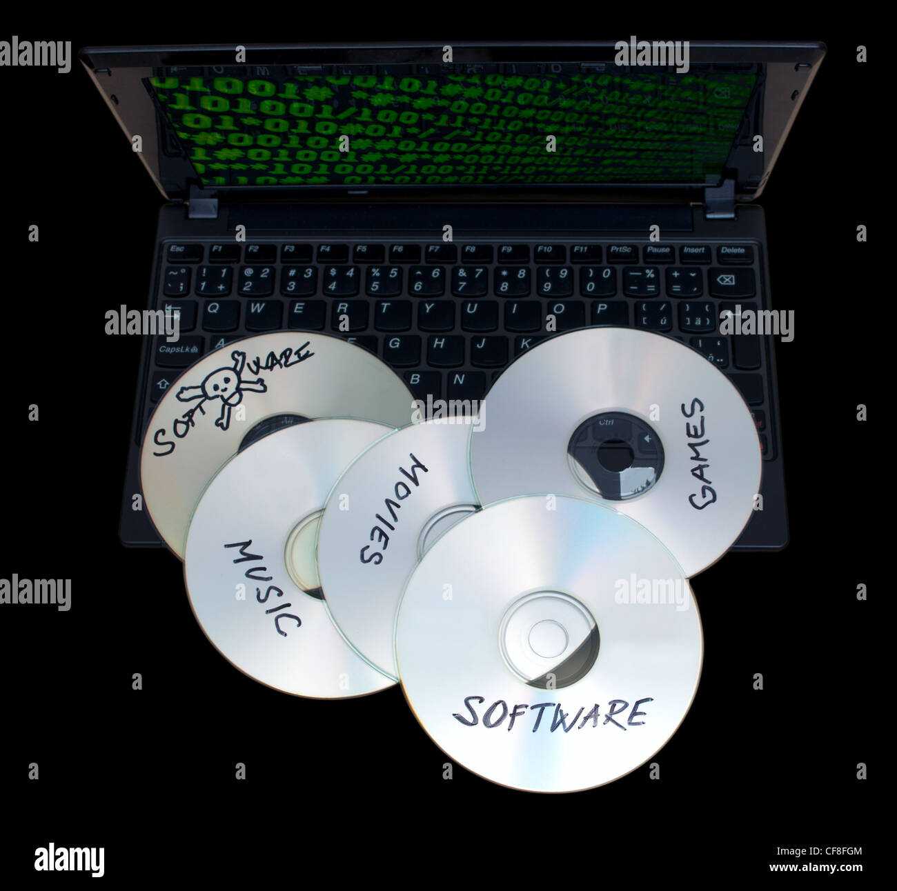 Piraterie-Konzept - gebrannte CDs mit illegaler Software auf Tastatur von Notebook - auf schwarzem Hintergrund isoliert Stockfoto