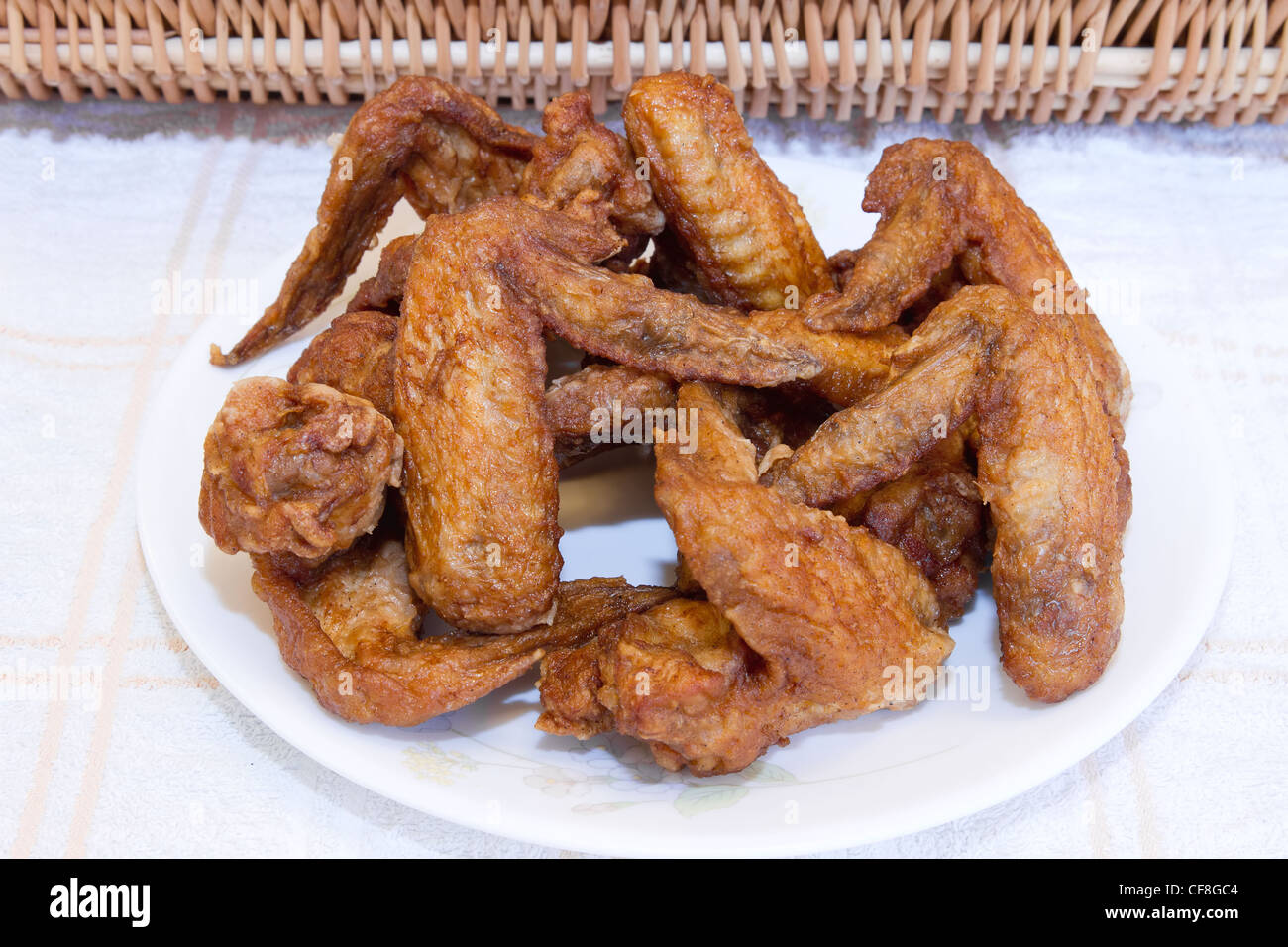 Platte von Deep Fried Chicken Wings mit Picknick-Korb Stockfoto