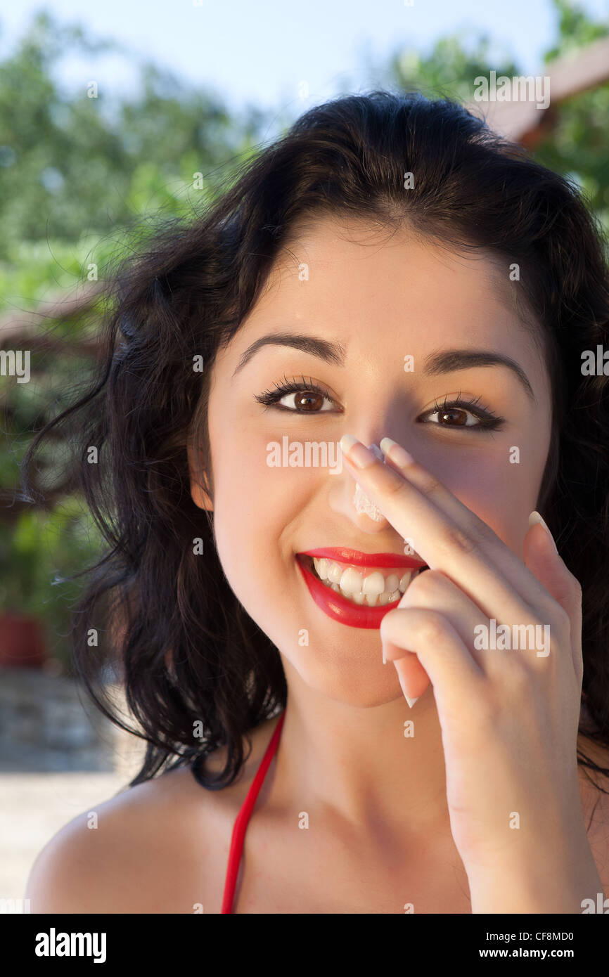 Hübsche junge Frau setzen Sonnenschutz Creme auf der Nase Stockfotografie -  Alamy
