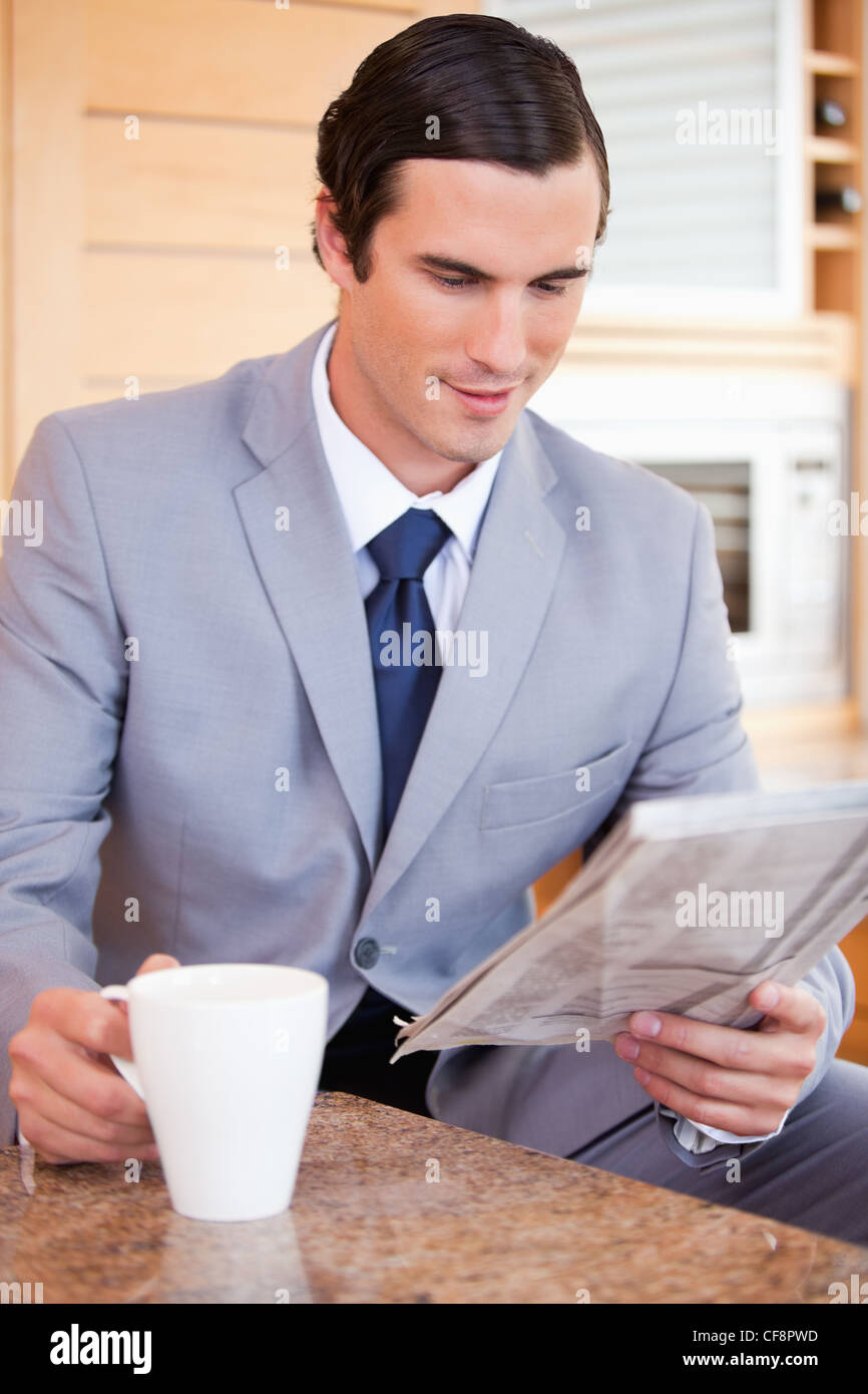 Geschäftsmann in der Küche lesen Nachrichten und Kaffeetrinken Stockfoto