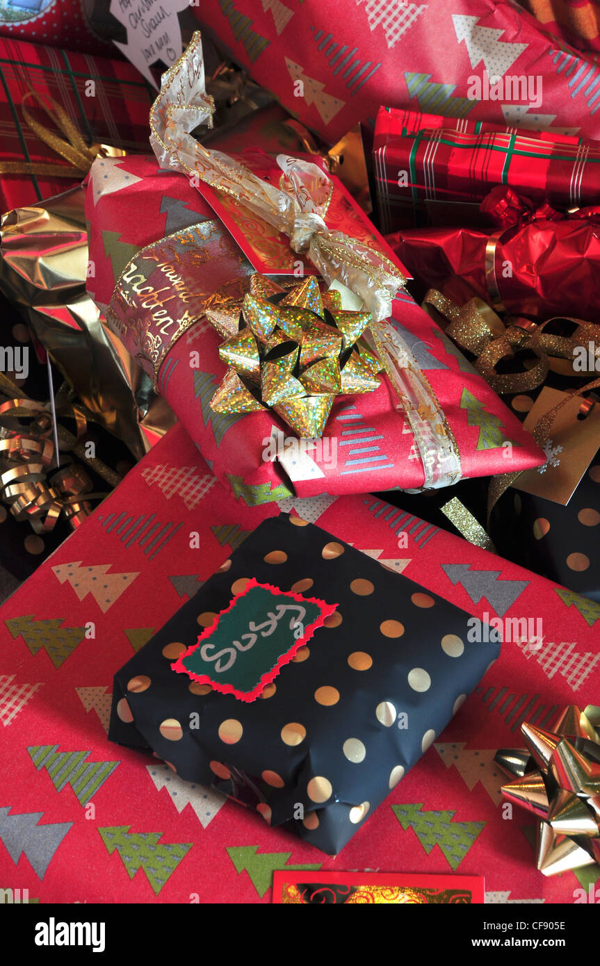 Eine Sammlung von Weihnachten präsentiert eingewickelt in rot und schwarz mit goldenen Bändern UK Stockfoto