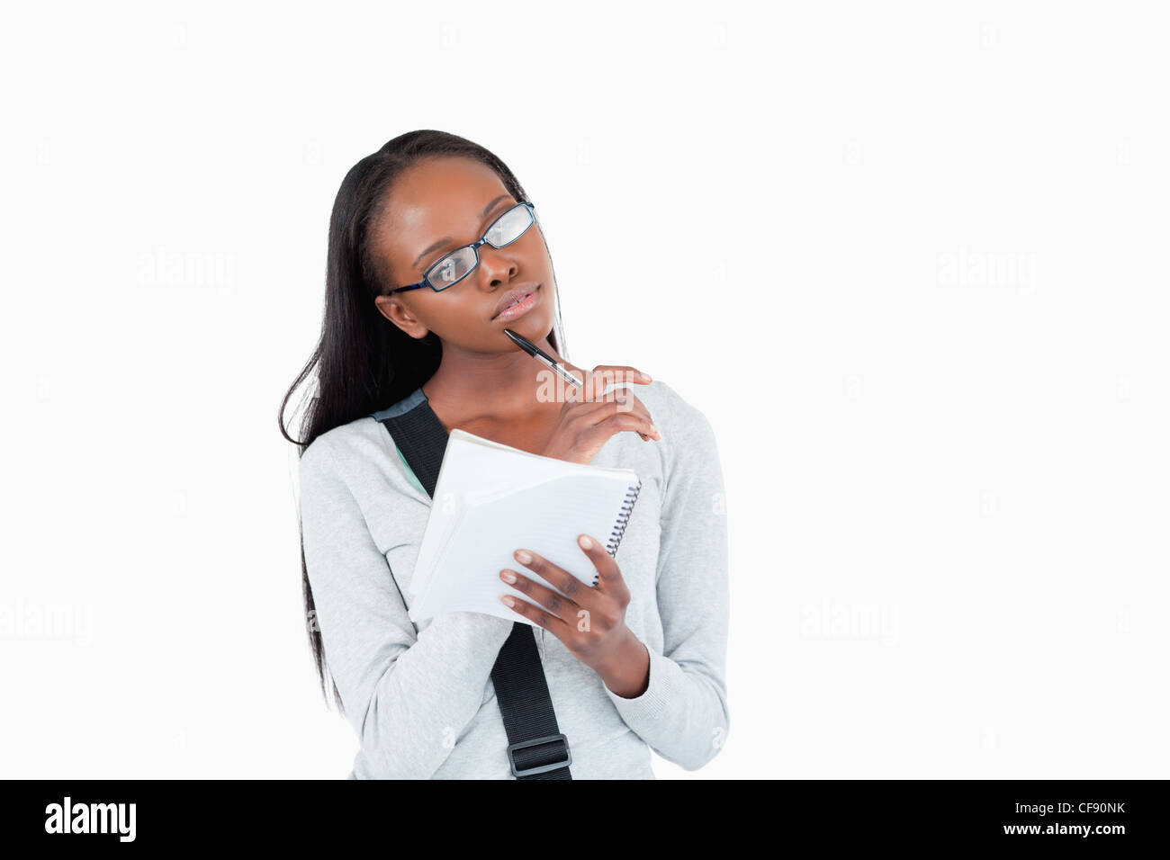 Junge Frau mit Brille und Notizblock in Gedanken Stockfoto