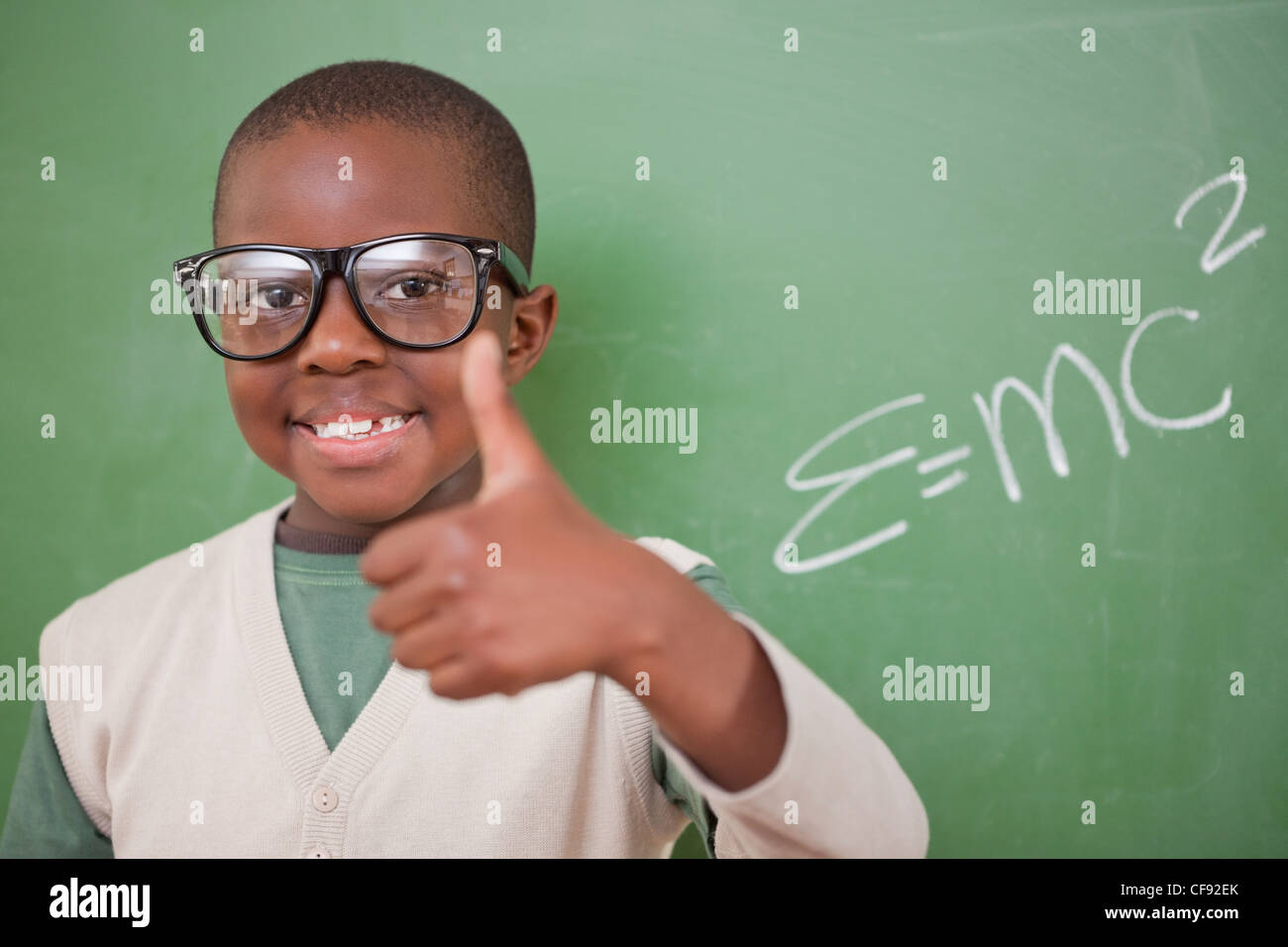 Schuljunge posiert mit der Masse – Energie-Äquivalenz Formel und der Daumen Stockfoto
