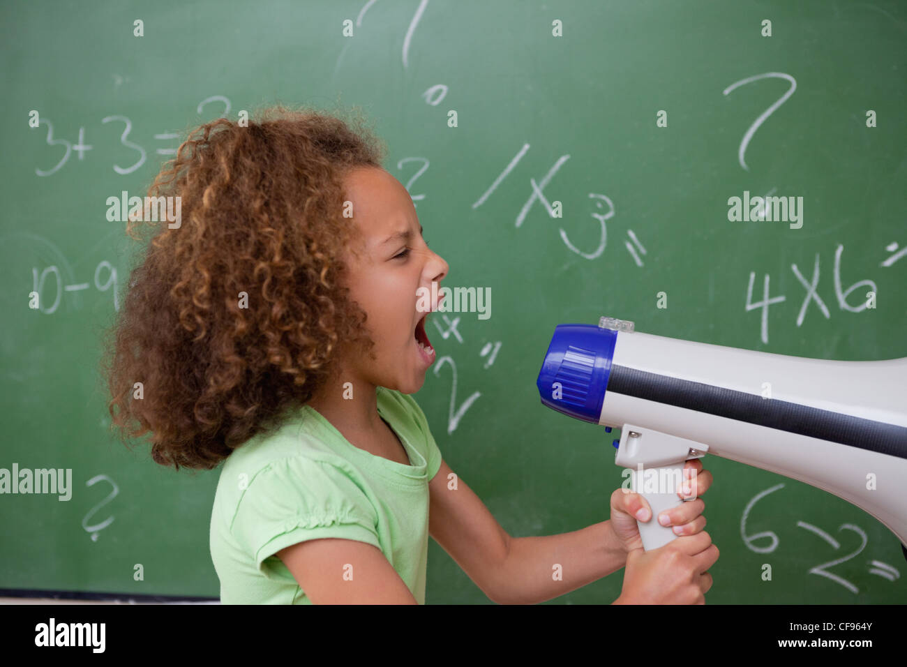 Seitenansicht einer Schülerin, die durch ein Megaphon schreien Stockfoto