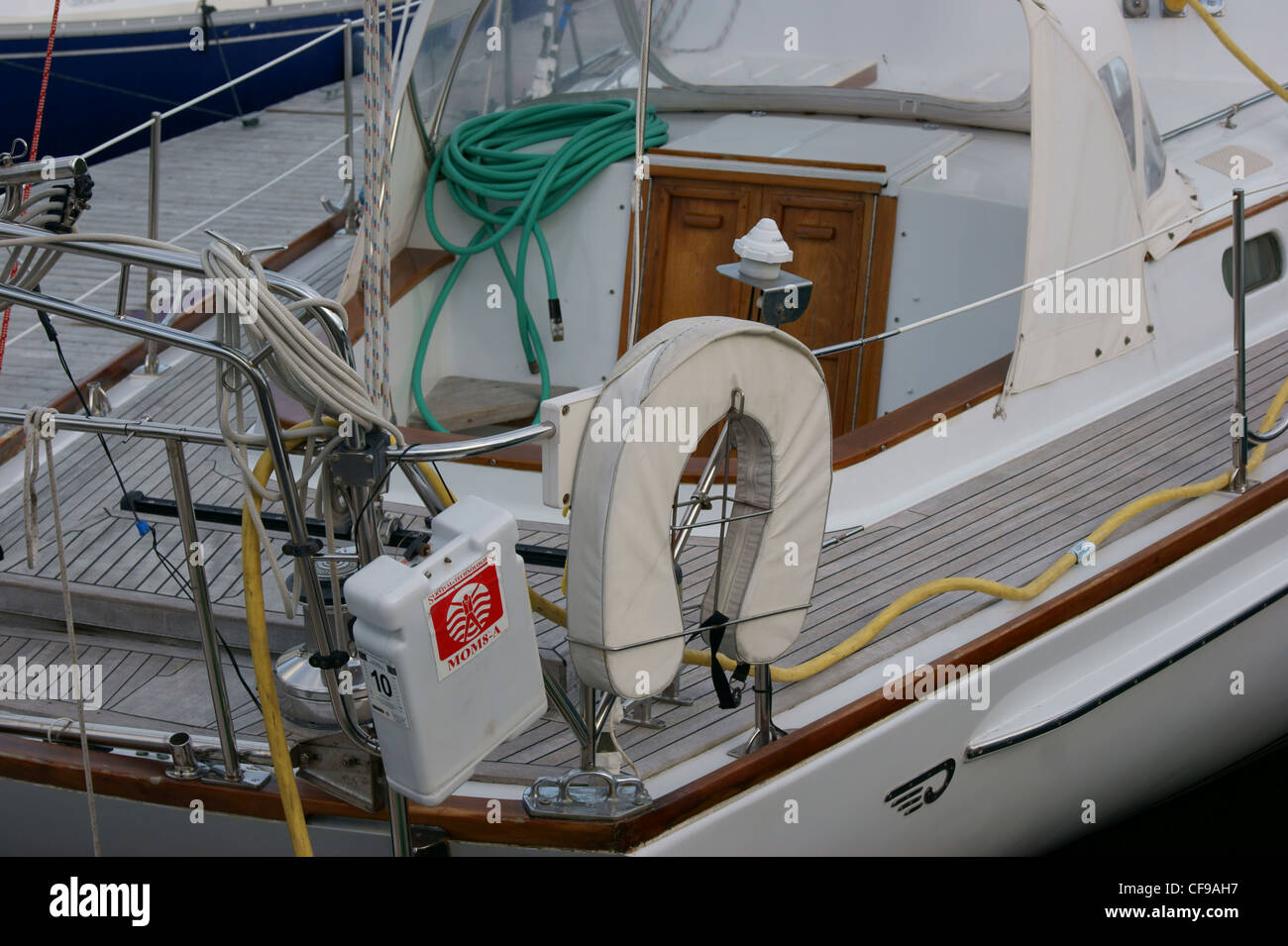 USCG genehmigten Typ 5 Hufeisen Boje neben einem Mann über Bord-Modul auf einem Segelboot mit Takelage und Cockpit im Hintergrund. Stockfoto