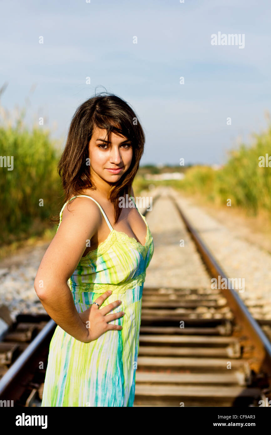 Blick auf ein schönes Mädchen mit einem Frühling Kleid auf einer Eisenbahn. Stockfoto