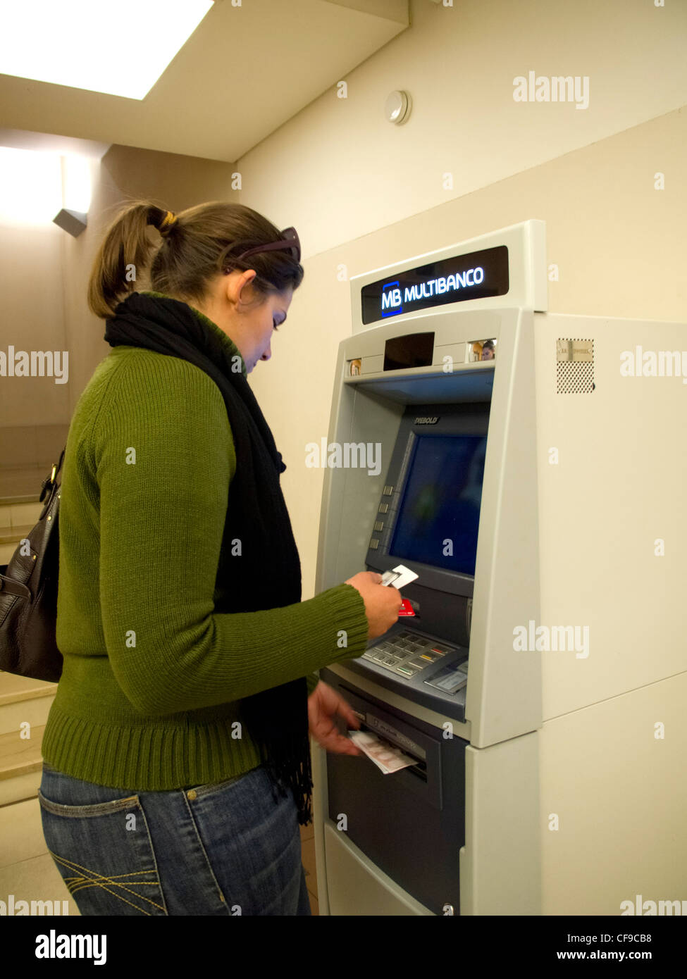 Junge Frau mit Geldautomaten Bargeld beziehen Stockfoto