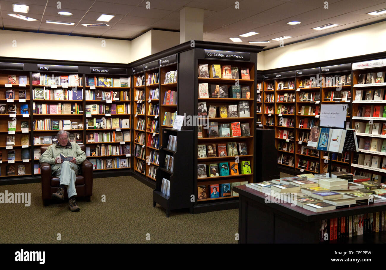 Ein Mann sitzen Lesung in einem Buchladen Waterstones, Cambridge UK Stockfoto Ein Mann sitzen Lesung in einem Buchladen Waterstones, Cambridge UK Stockfoto