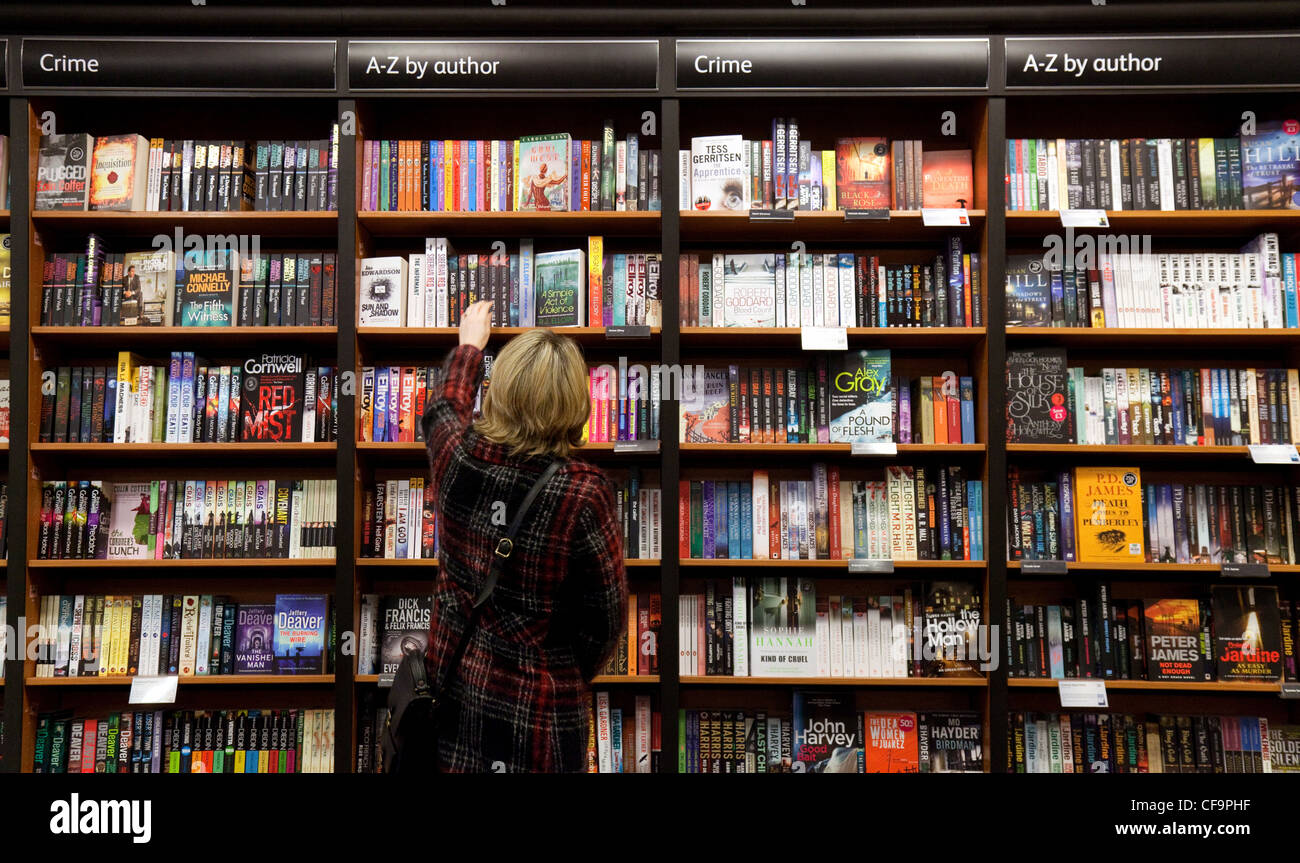 Buchhandlung UK - Erwachsene Frau, die Kriminalromane zum Lesen kauft, Waterstones Buchhandlung, Cambridge UK Stockfoto