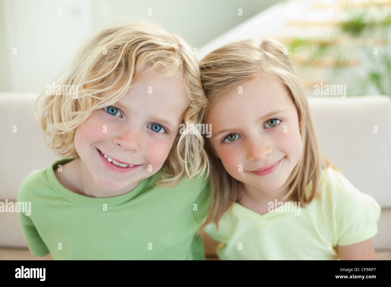 Lächelnde Geschwister auf dem sofa Stockfoto