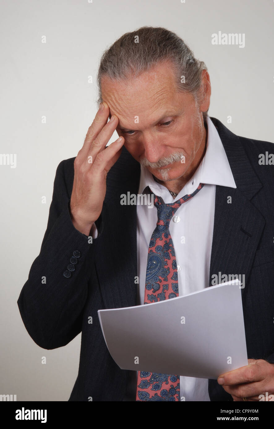 Betonte, besorgt Geschäftsmann Blick auf Papiere, gelockerten Krawatte und Jacke Stockfoto