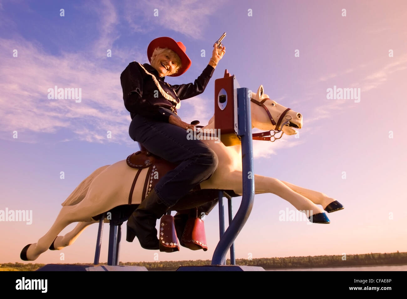 Ältere Frau mechanische Reitpferd Cowboy Kostüm, Kanada. Stockfoto