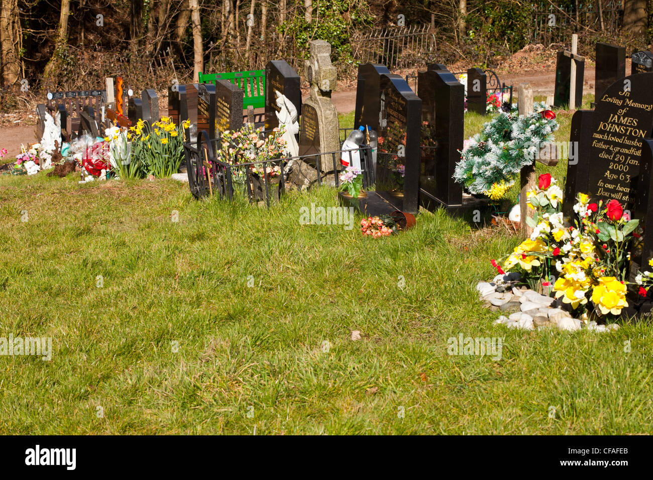 Kopf-Steinen im Kirchhof mit frischen Schnittblumen, Grabsteine auf dem