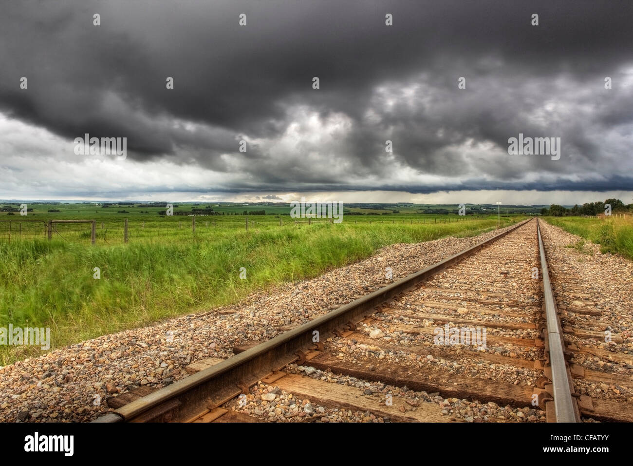 Railroad tracks mit Wolken im Hintergrund in der Nähe von Didsbury, Alberta, Kanada Stockfoto
