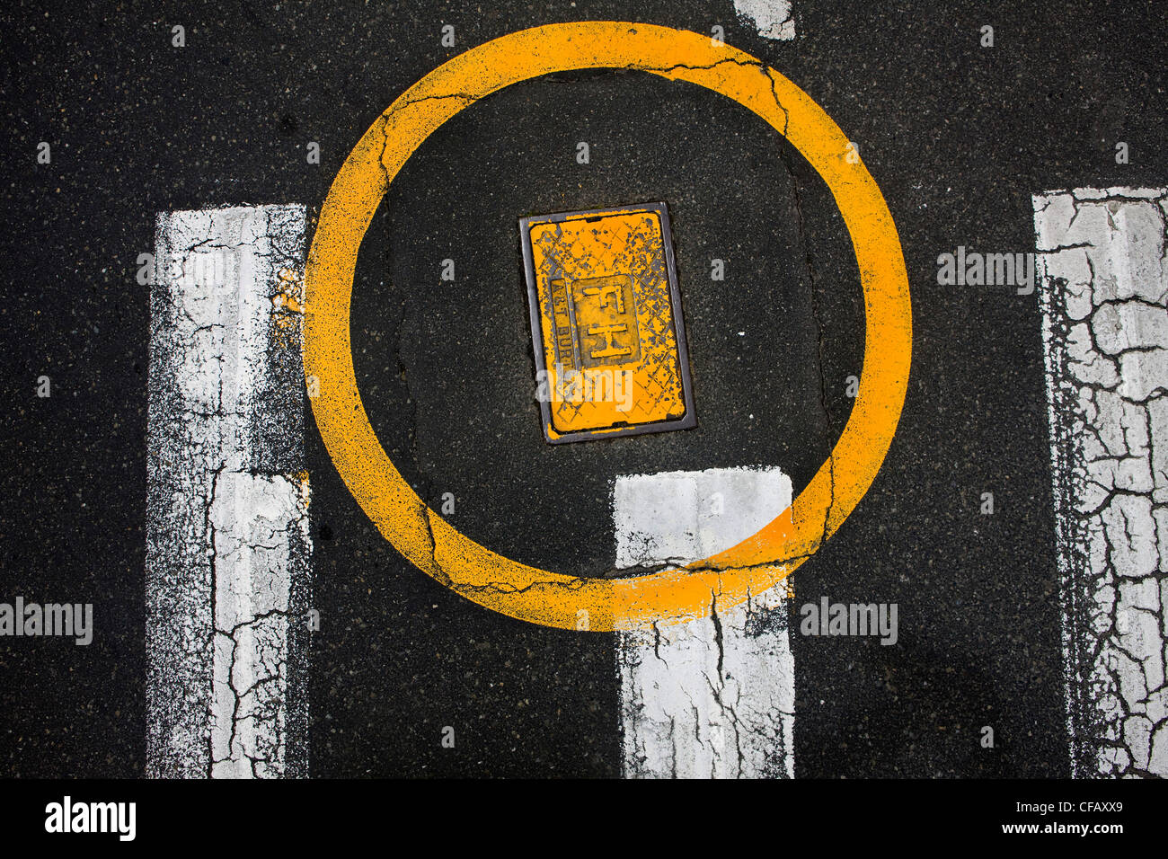 Gelber Kreis runde gelbe Kanaldeckel auf Straße Stockfoto