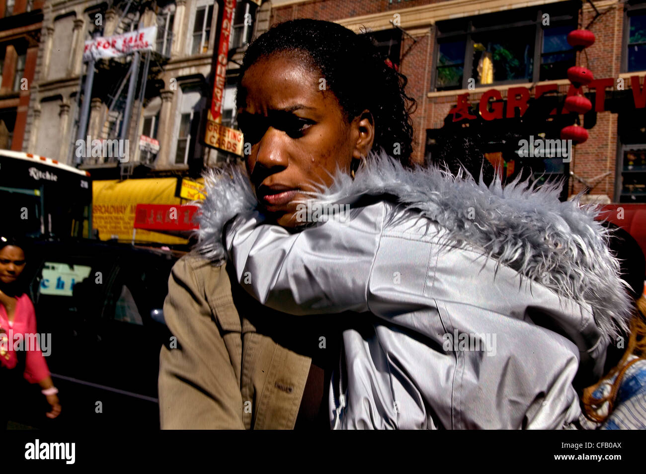 Eine Frau trägt ihr Kind durch einer New Yorker Straße. Stockfoto
