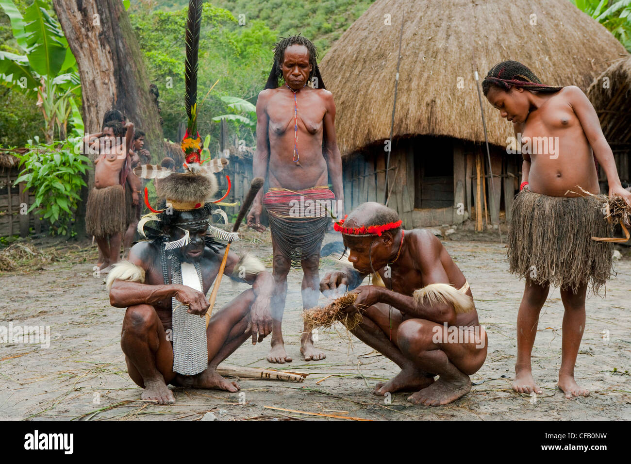 Dani Stammesmitglieder machen Feuer in ihrem traditionellen Dorf, Neuguinea, Indonesien. Stockfoto