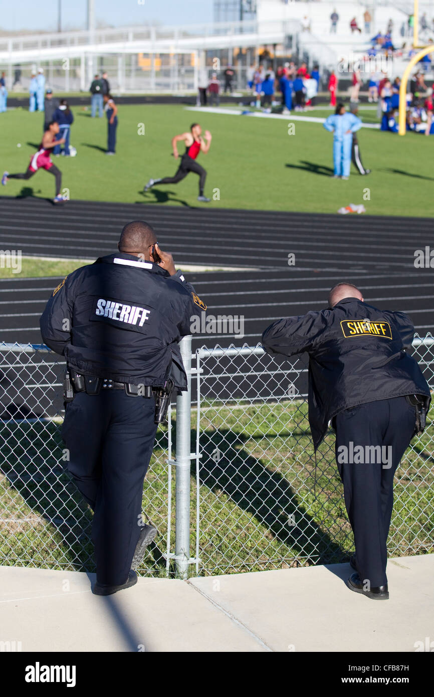 Travis County (Texas) Sheriffs Offiziere beobachten über einen Samstag Track Meet an Bastrop Cedar Creek High School östlich von Austin. Stockfoto