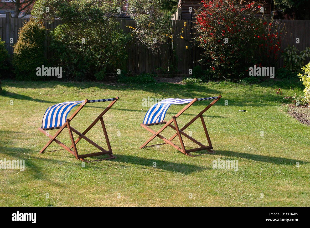 Vororte von London: zwei leeren blaue-weiße gestreifte Liegestühlen im Gardenon Rasen Stockfoto