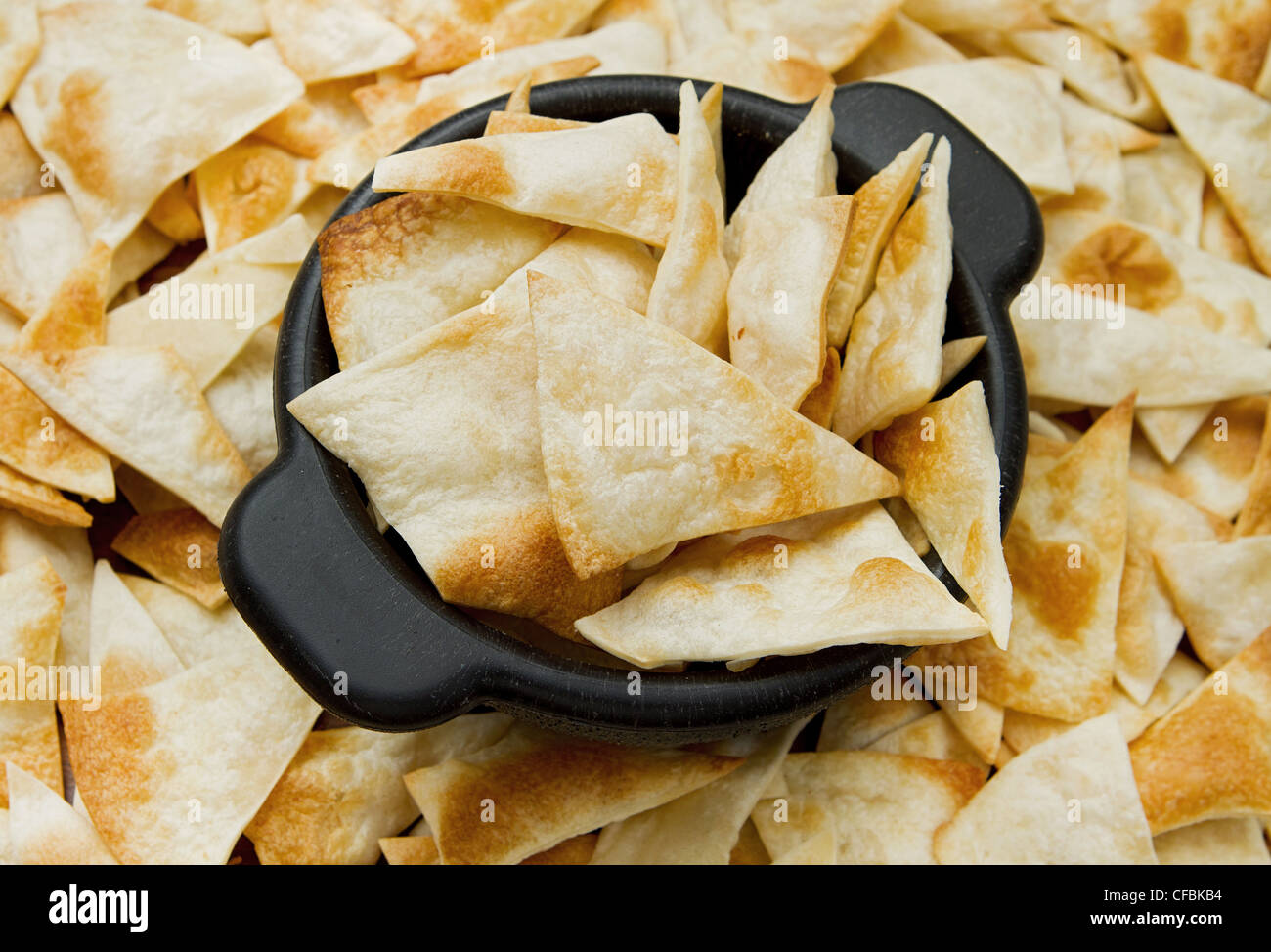 Haufen von Hause aus Tortilla-chips in einer schwarzen Schale Stockfoto