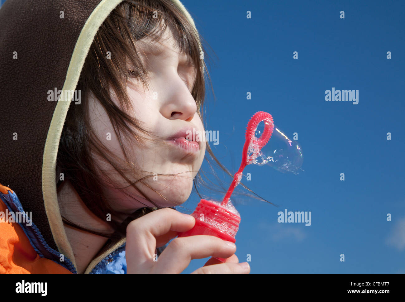 kleine Mädchen durch Spiel mit den Seifenblasen Stockfoto